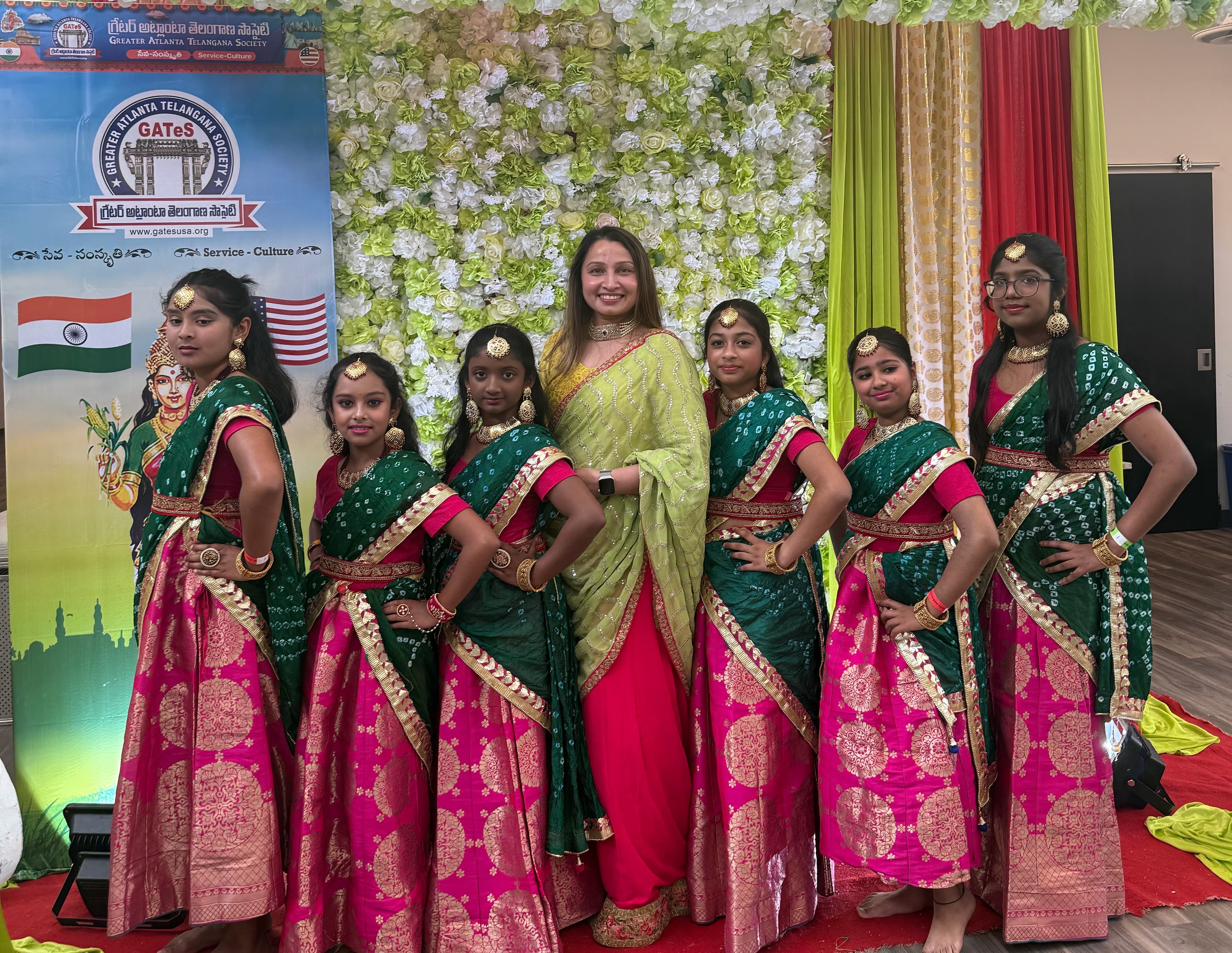 Garima Dance Academy students with the instructor in green and pink traditional attire at a Telangana Society community event